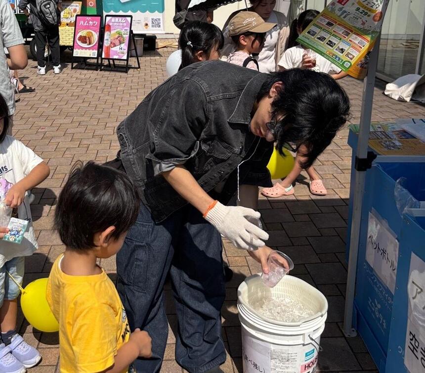 子どもに分別の仕方を教える生徒