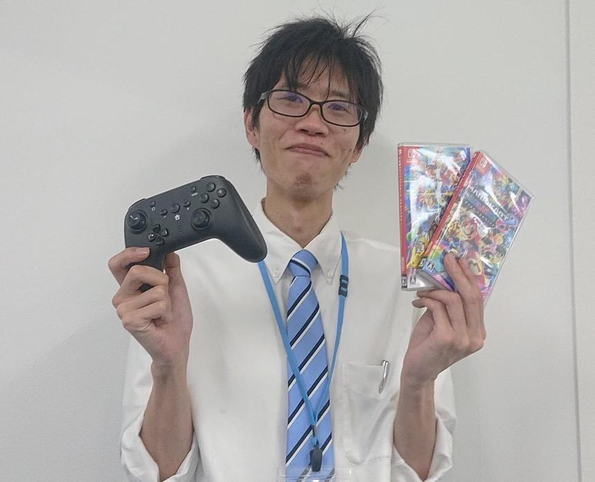 ゲーム機材を手に持つ男性コーチ