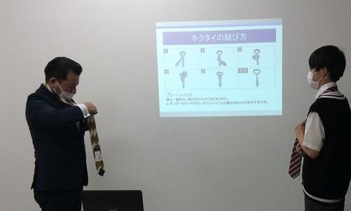 ネクタイの結び方を実演中