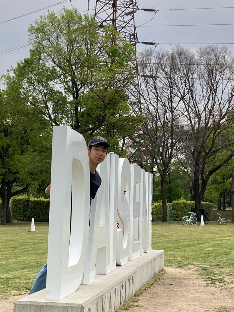 新入生歓迎イベントで訪れた大山公園のオブジェと写る生徒